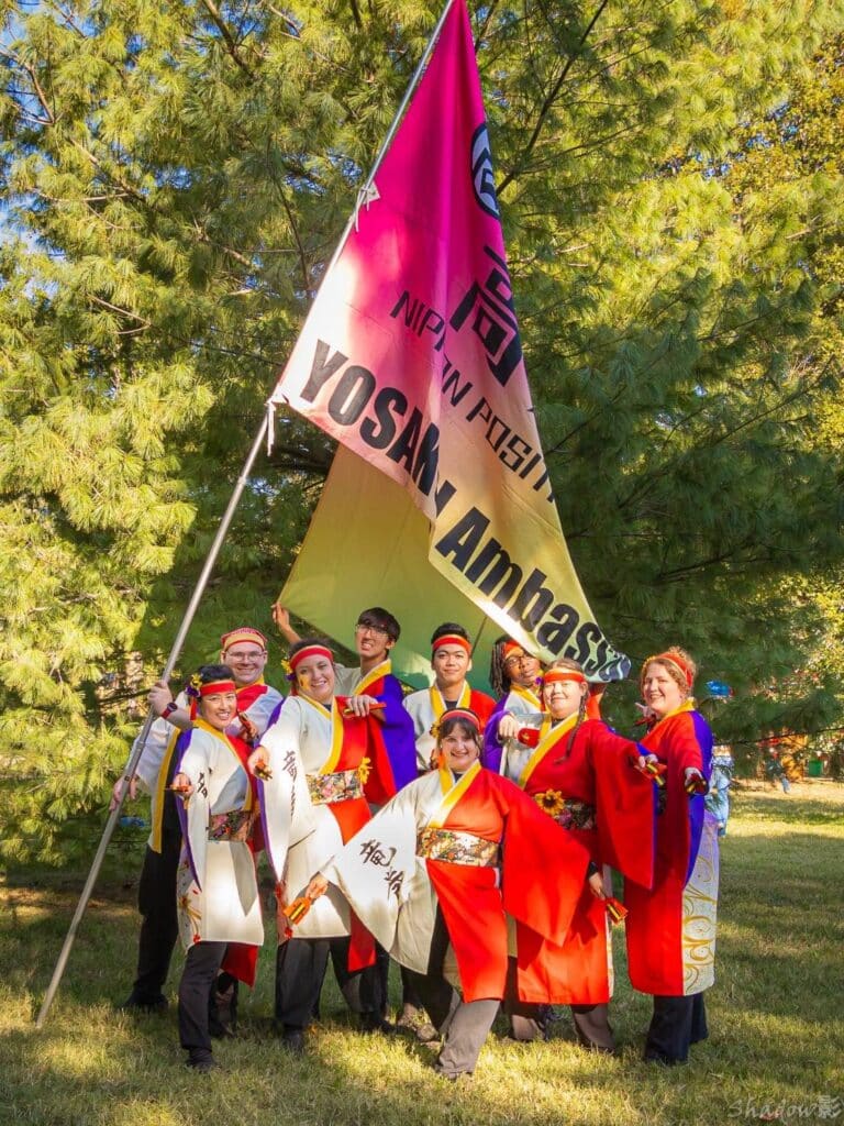 Group of Tatsumaki Yosakoi team members holding Yosakoi Ambassador flag from Kochi Japan